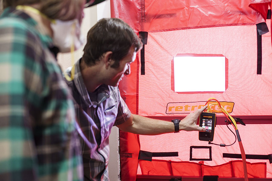 Assessor explaining blower door test results